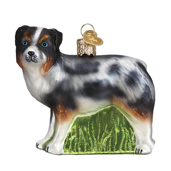 Blue merle Australian Shepherd ornament with copper points on green glitter grass, side view