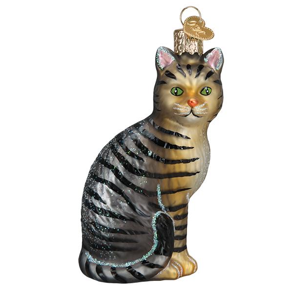 Tabby cat glass ornament, front view, charcoal and caramel stripes with green eyes and a gold cap, on white
