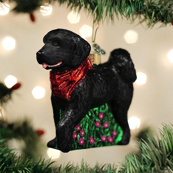Black doodle glass ornament hanging on a Christmas tree with warm twinkling lights