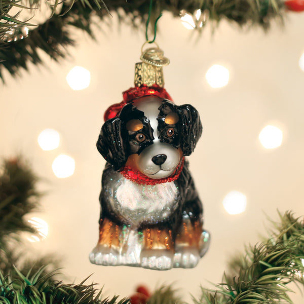 Bernedoodle puppy glass ornament hanging on a twinkling Christmas tree