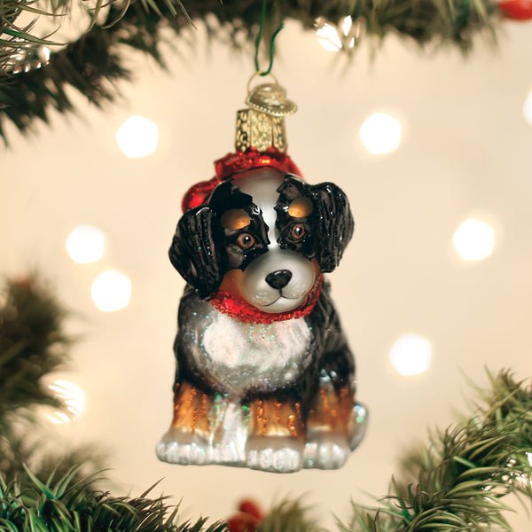 Bernedoodle puppy glass ornament hanging on a twinkling Christmas tree