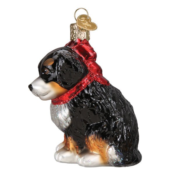 Side profile of the Bernedoodle puppy ornament showing black, white, and tan coat and red bow