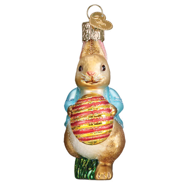 Front of the Peter Rabbit ornament holding the pink and gold Easter egg against his chest, on white