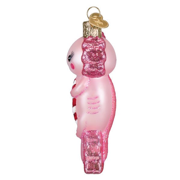 Side view of the axolotl ornament with its curled pink tail and candy cane, on white