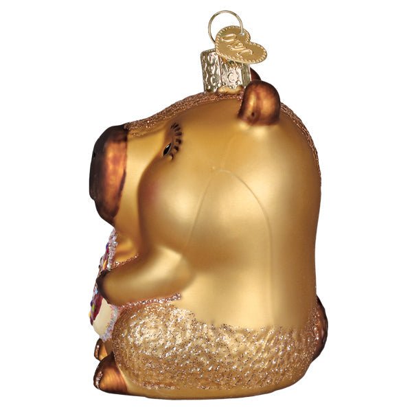 Side profile of the capybara ornament with its brown snout and donut tucked in front, on white