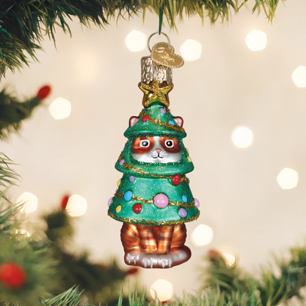 Cat in a Christmas tree costume glass ornament hanging on a lit Christmas tree