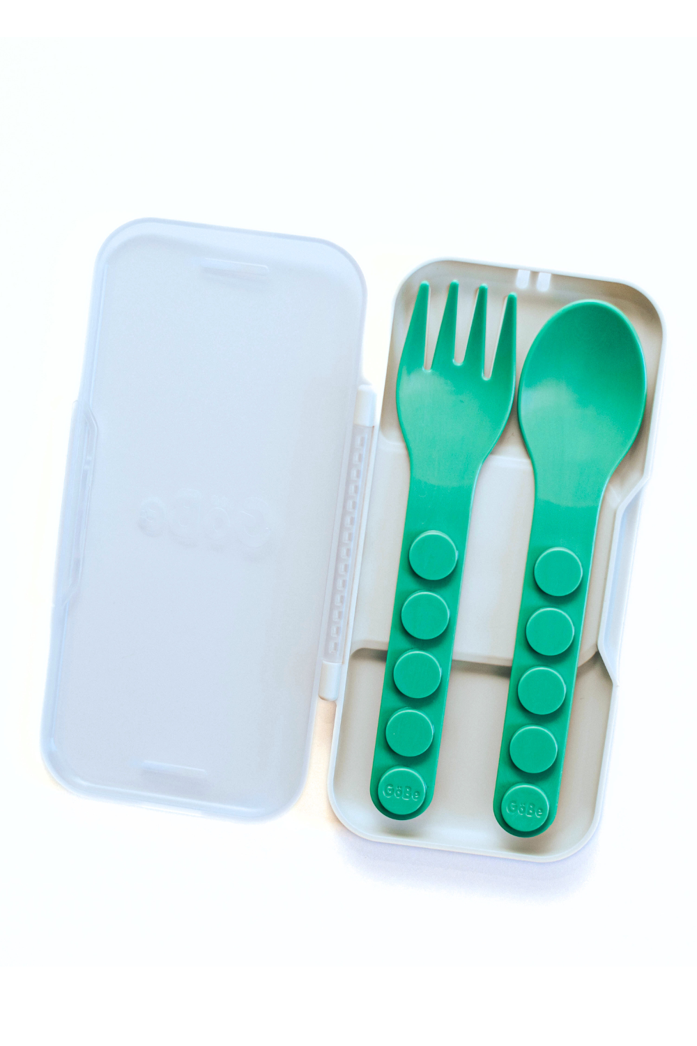 Open travel case holding a green GoBe fork and spoon side by side