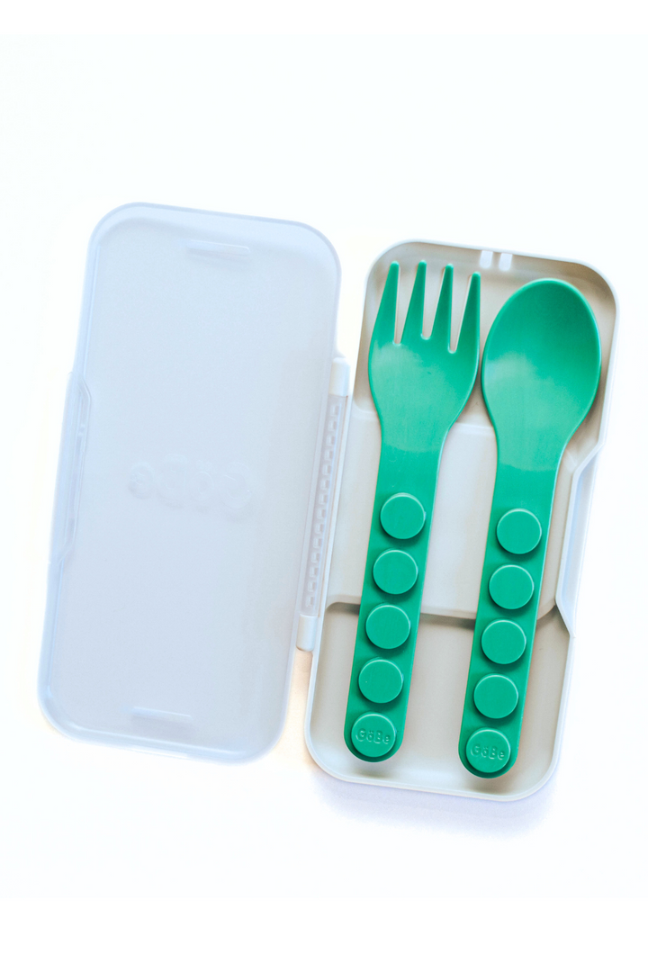 Open travel case holding a green GoBe fork and spoon side by side