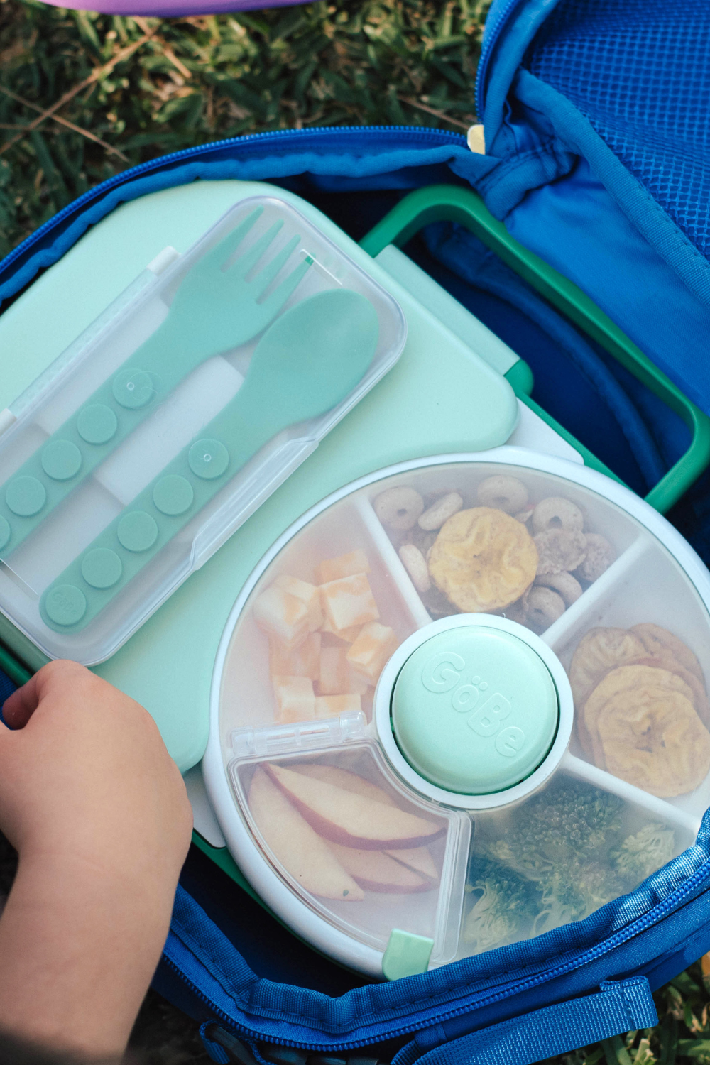 Open blue GoBe lunch bag holding a lunchbox, snack spinner, and utensils