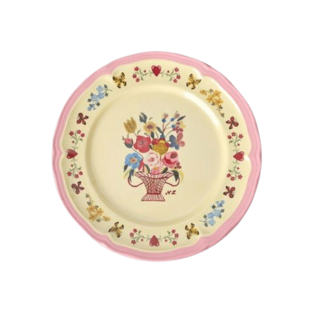 Nathalie Lété melamine side plate with a painted flower basket center, floral border, and scalloped pink rim, top view