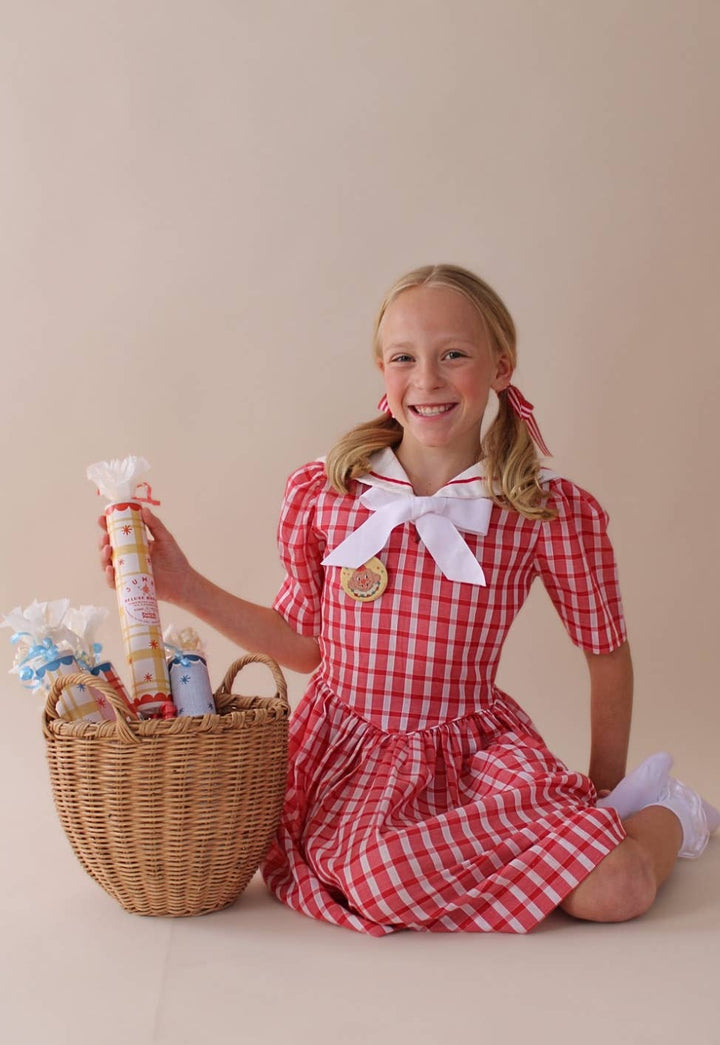 Child with a basket of jumbo surprise bon bons including the blue plaid colorway for a holiday table