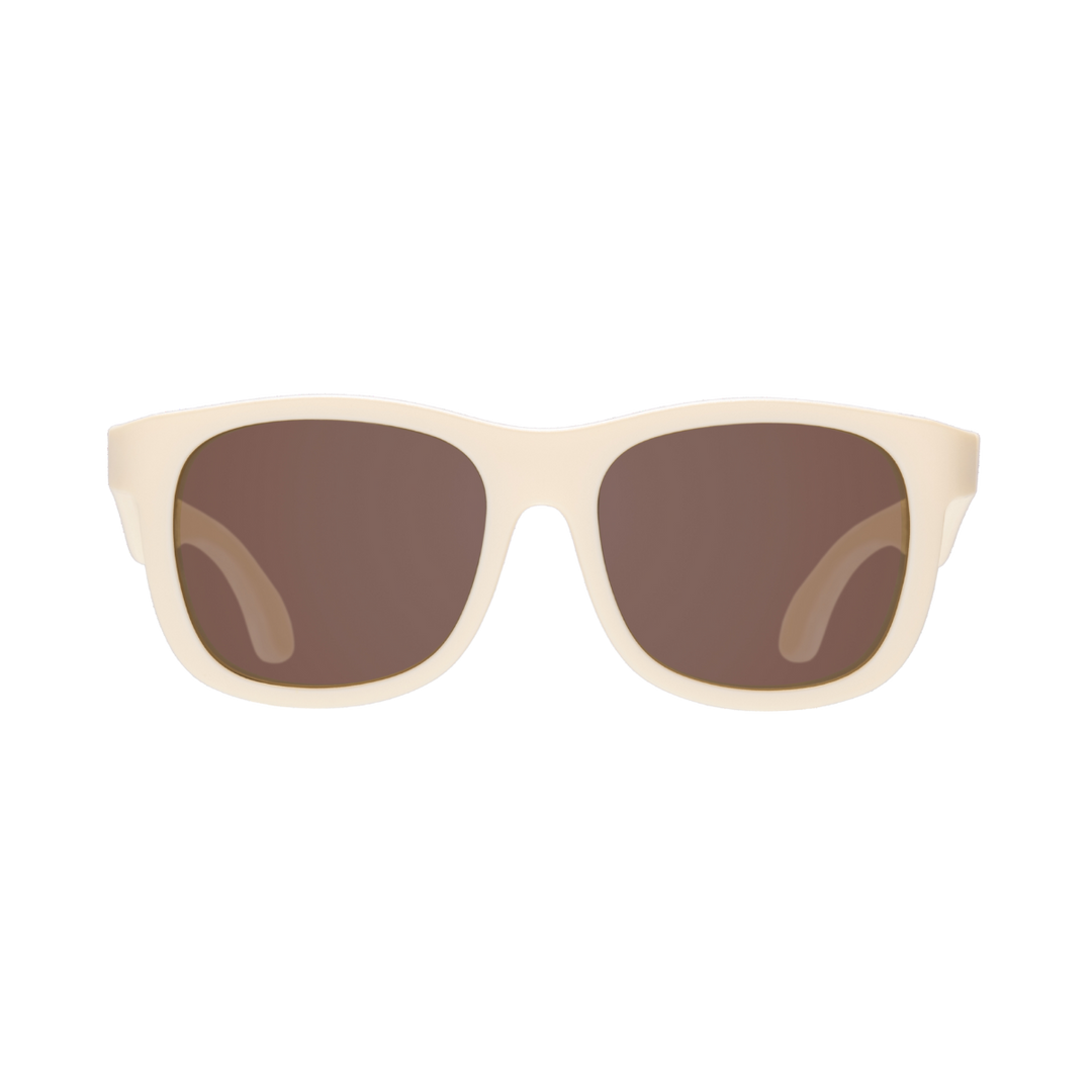 Cream aviator kids sunglasses shown from the front with amber lenses on a plain background.