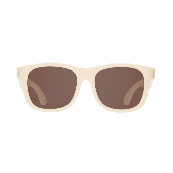 Cream aviator kids sunglasses shown from the front with amber lenses on a plain background.
