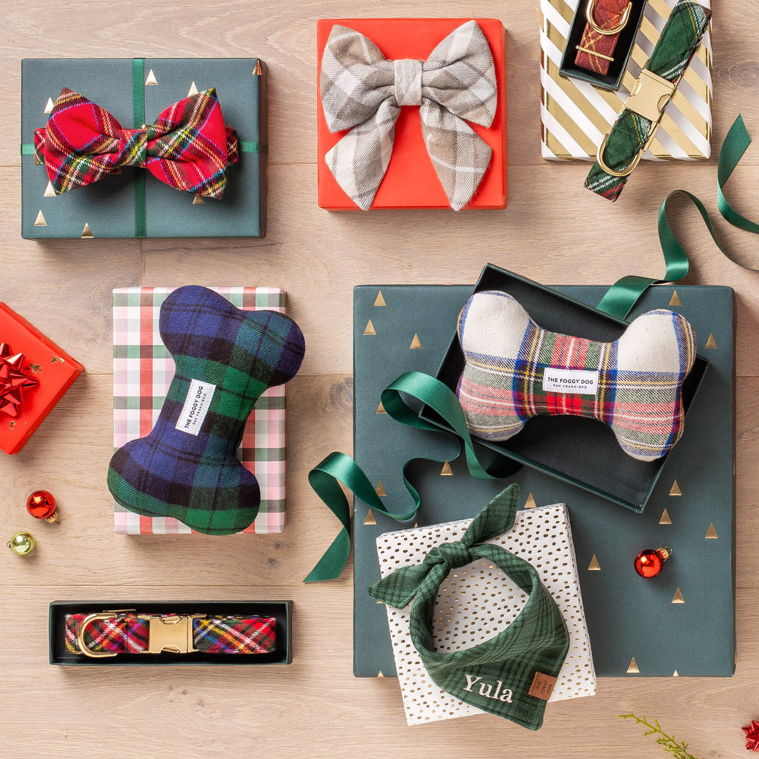Wrapped gifts topped with tartan and plaid dog bows, bone toys, and a green bandana