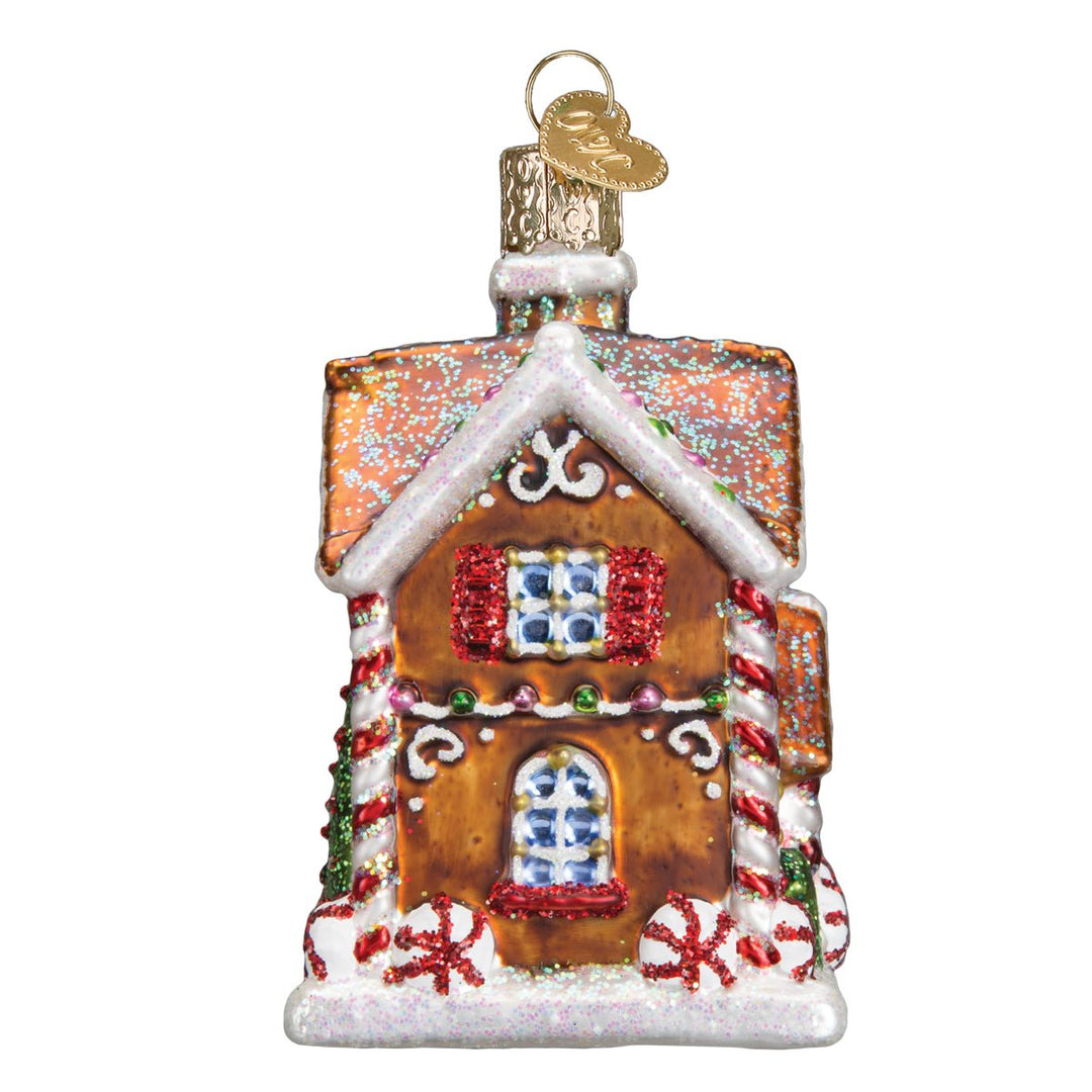 Side of the Christmastime cottage ornament showing the arched door and snowy roof edge