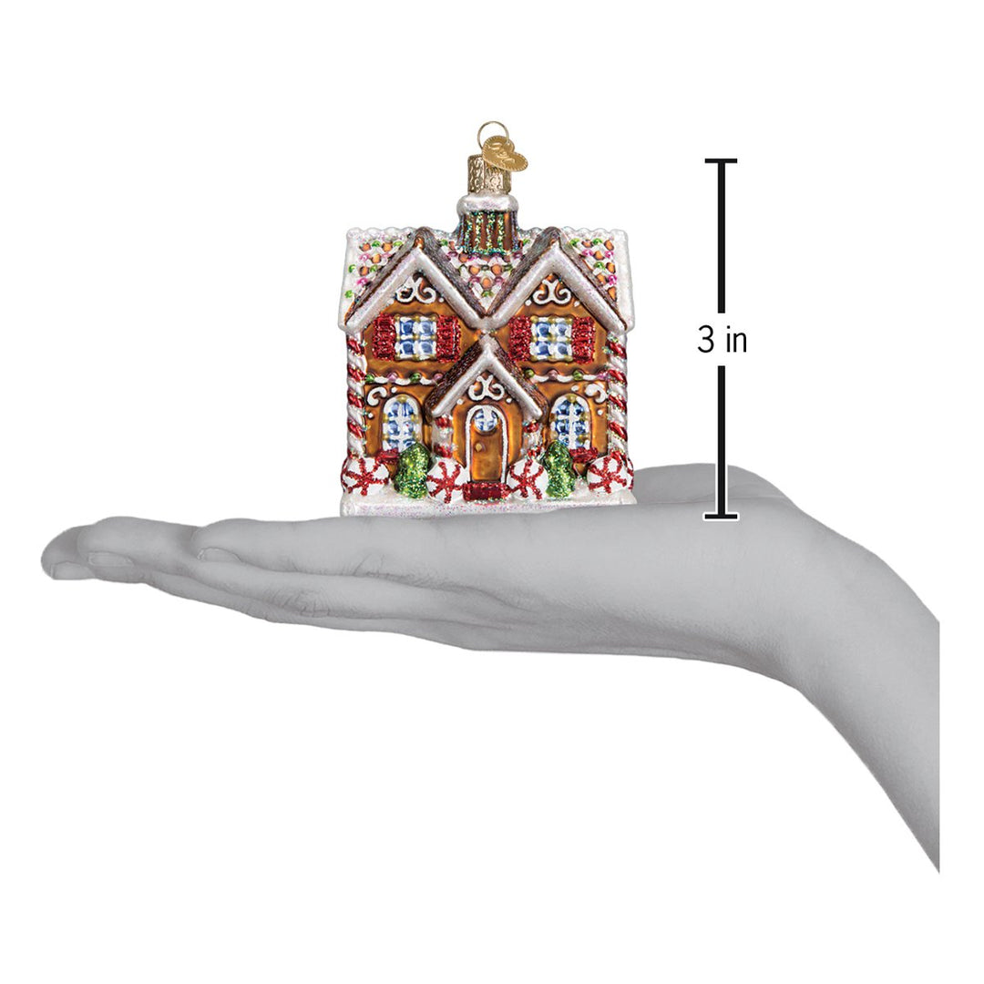 Christmastime cottage ornament on an open palm with a 3 inch height marker
