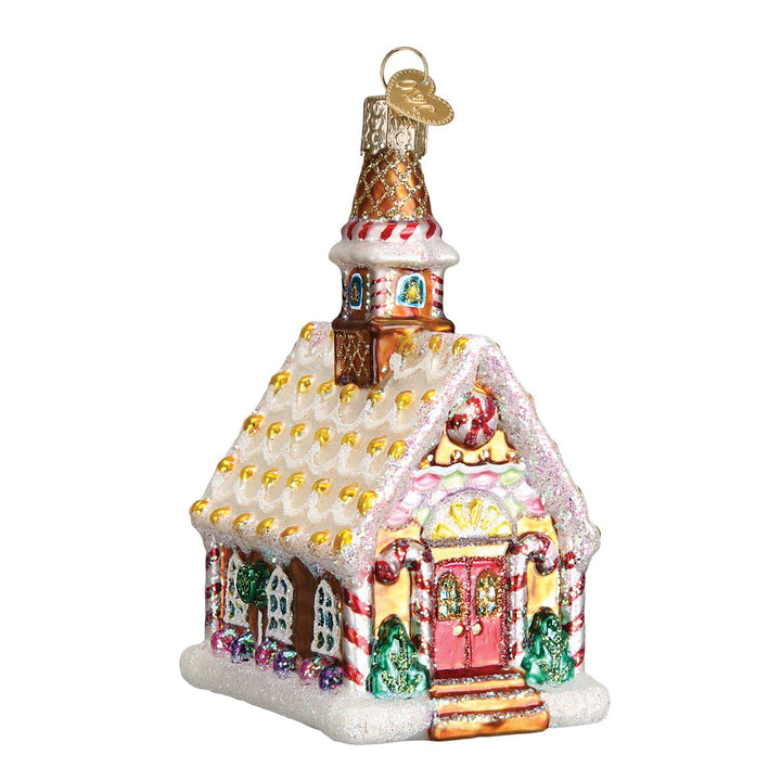 Front of the gingerbread church ornament with red doors, a candy-dotted white roof, and steeple, on white