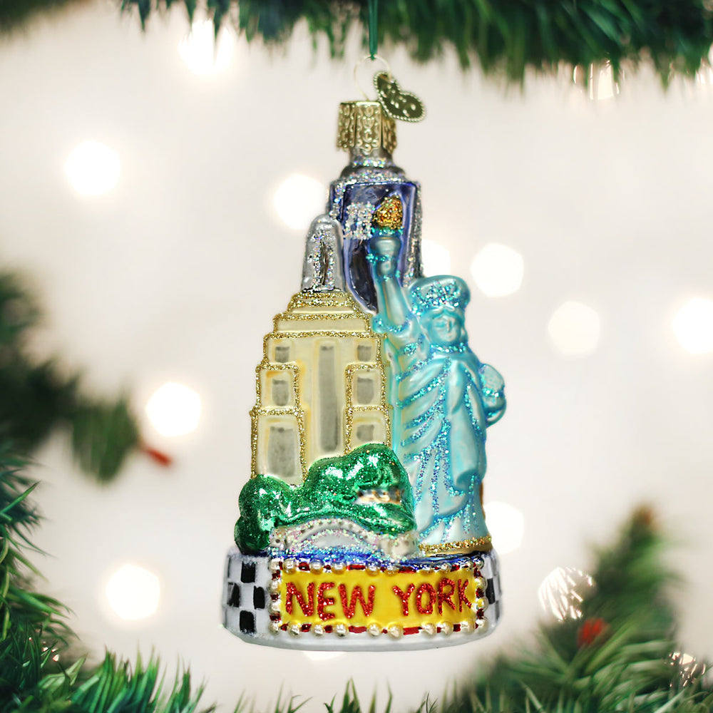 New York City ornament hanging on a Christmas tree with twinkle lights behind it