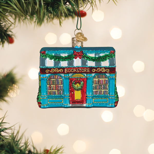 Bookstore Christmas ornament hanging on a tree branch with warm bokeh lights behind it