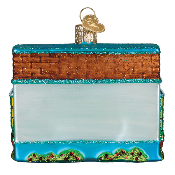 Back view of the bookstore ornament showing its brick-red roof and pale blue wall
