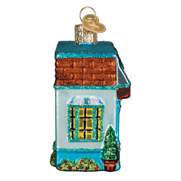 Side view of the bookstore ornament with a glowing yellow window and a small potted tree