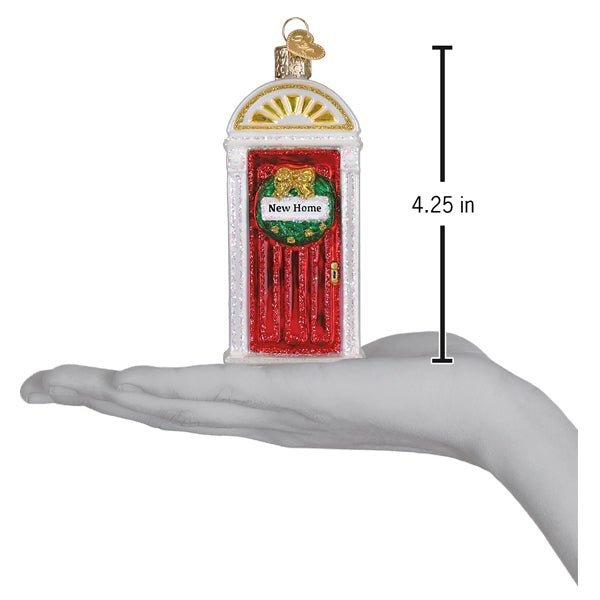 New Home door ornament resting on a hand with a 4.25 inch height marker for scale