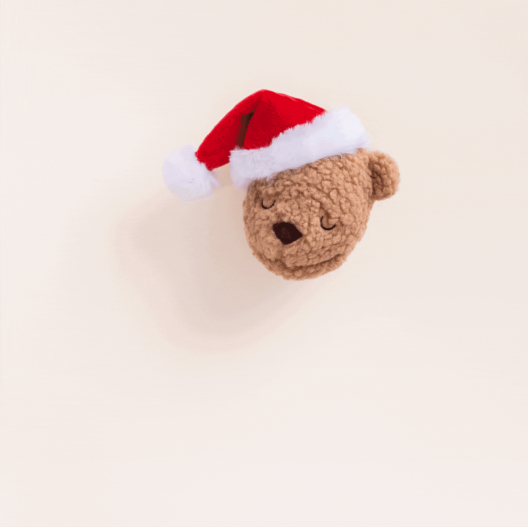 Animated clip of the Santa teddy bear dog toy on a cream backdrop