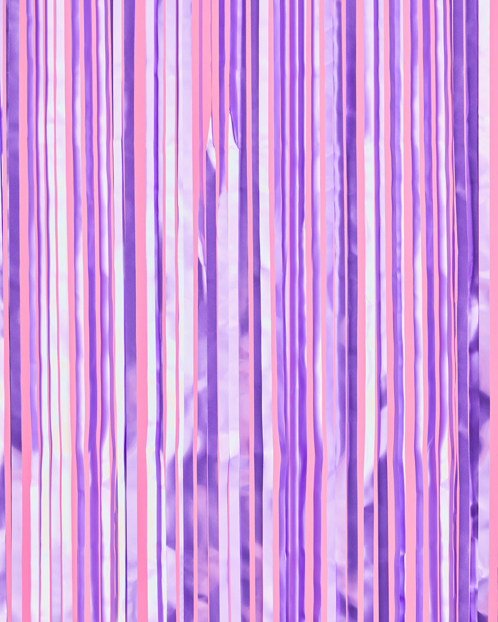 Lilac and violet purple foil fringe curtain hung full width as a party backdrop
