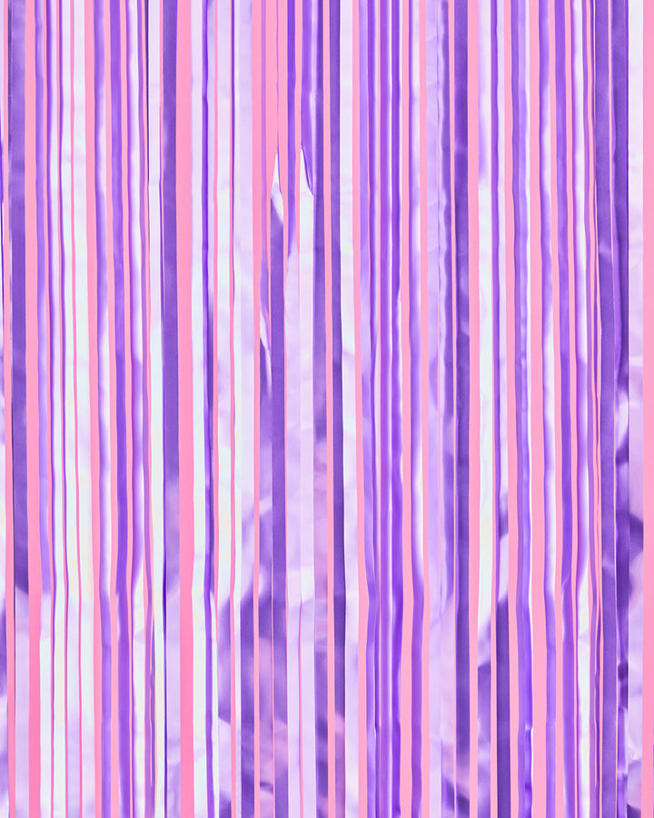Lilac and violet purple foil fringe curtain hung full width as a party backdrop