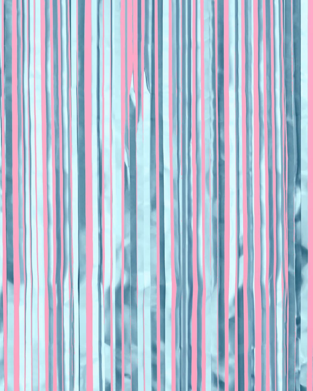 Light blue metallic fringe curtain strands hung against a pink wall as a bridal shower backdrop