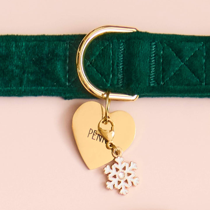 Green velvet dog collar on blush with a gold heart ID tag and white snowflake charm