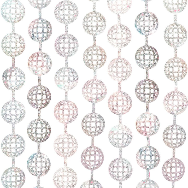 Silver disco ball foil curtain hung flat against a bright pink wall