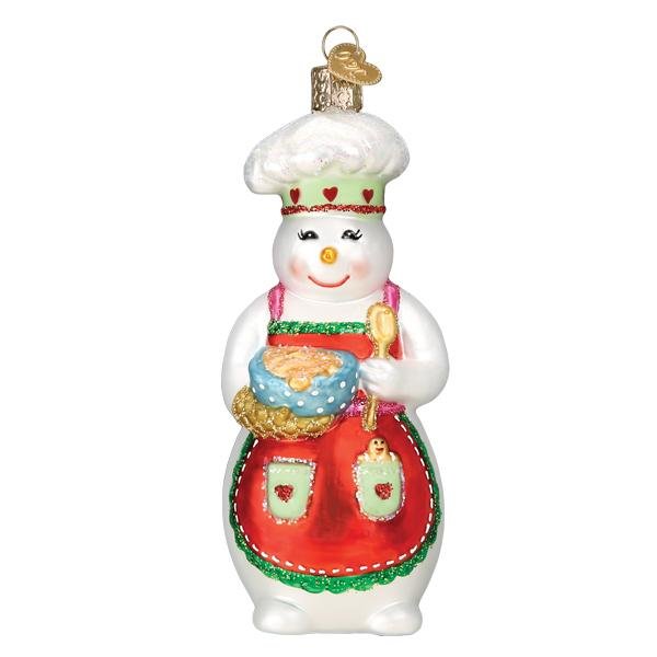 Front of the snow woman chef ornament in a chef hat and red apron, stirring a mixing bowl, on white