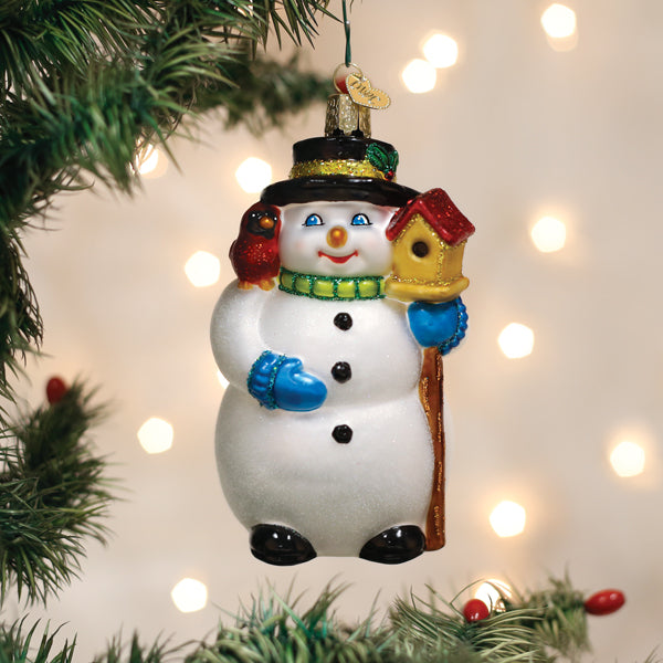 Snowman with cardinal glass ornament hanging on a lit Christmas tree