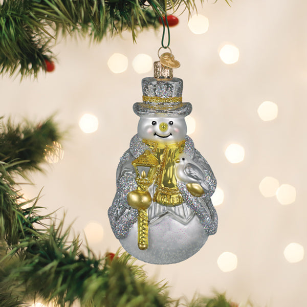 Sterling silver snowman glass ornament hanging on a lit Christmas tree