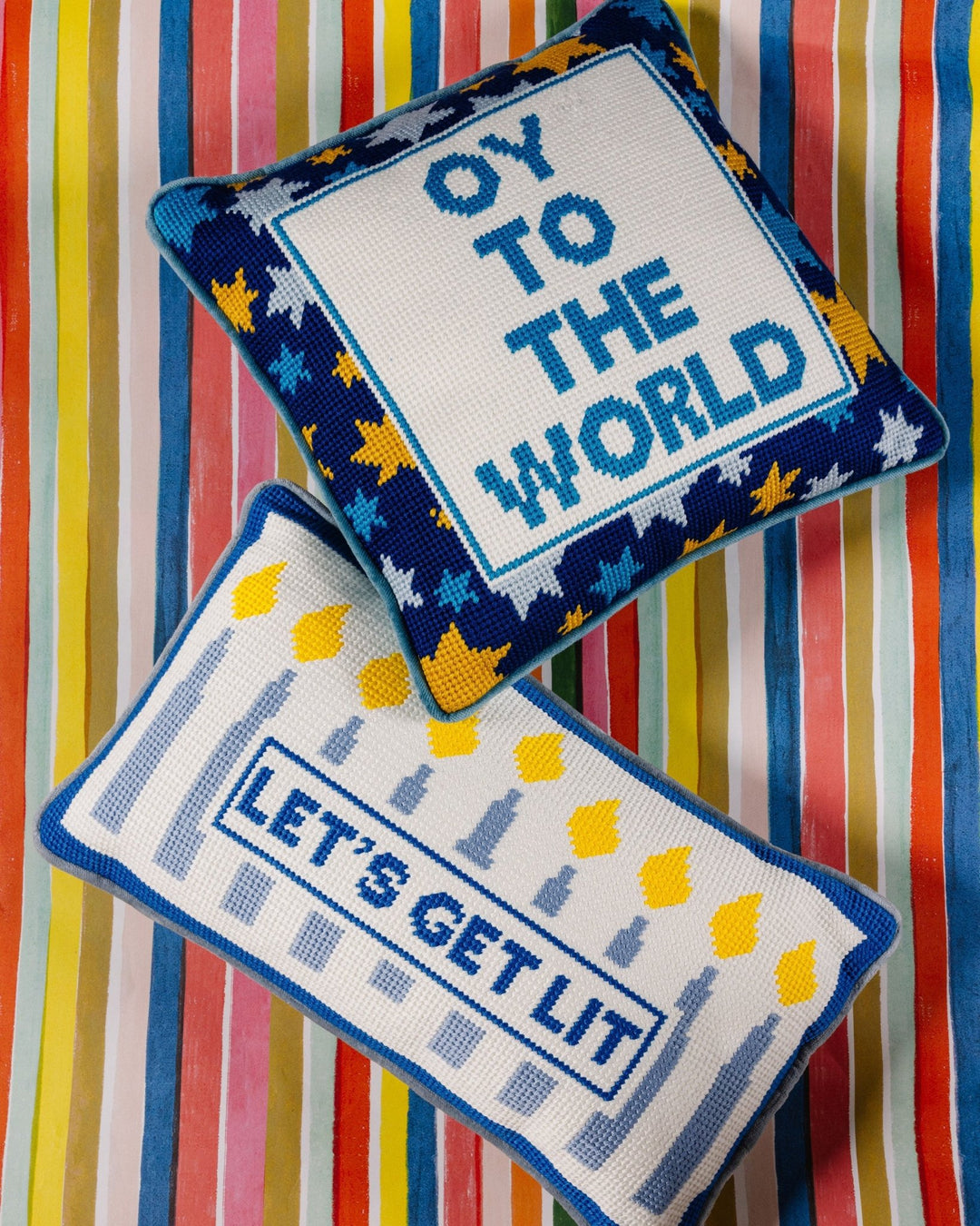 Oy to the World and Let's Get Lit Hanukkah needlepoint pillows with Star of David and menorah candle designs