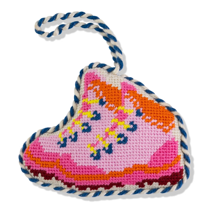 Pink snow boots needlepoint ornament, front view with orange cuff, navy laces, and navy and white cord