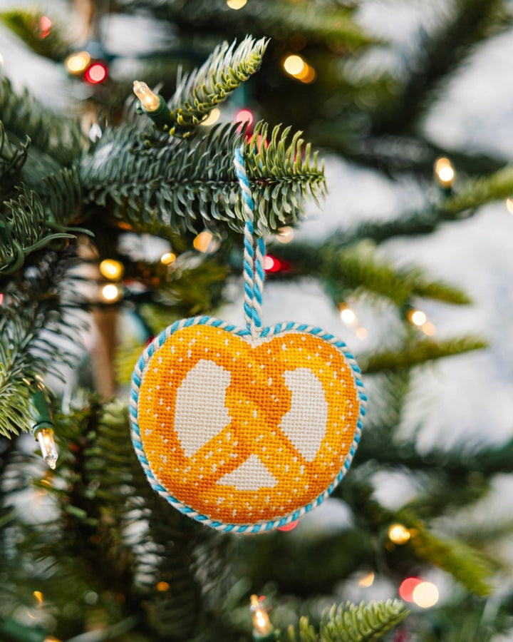 Pretzel ornament hanging on a Christmas tree branch among white lights