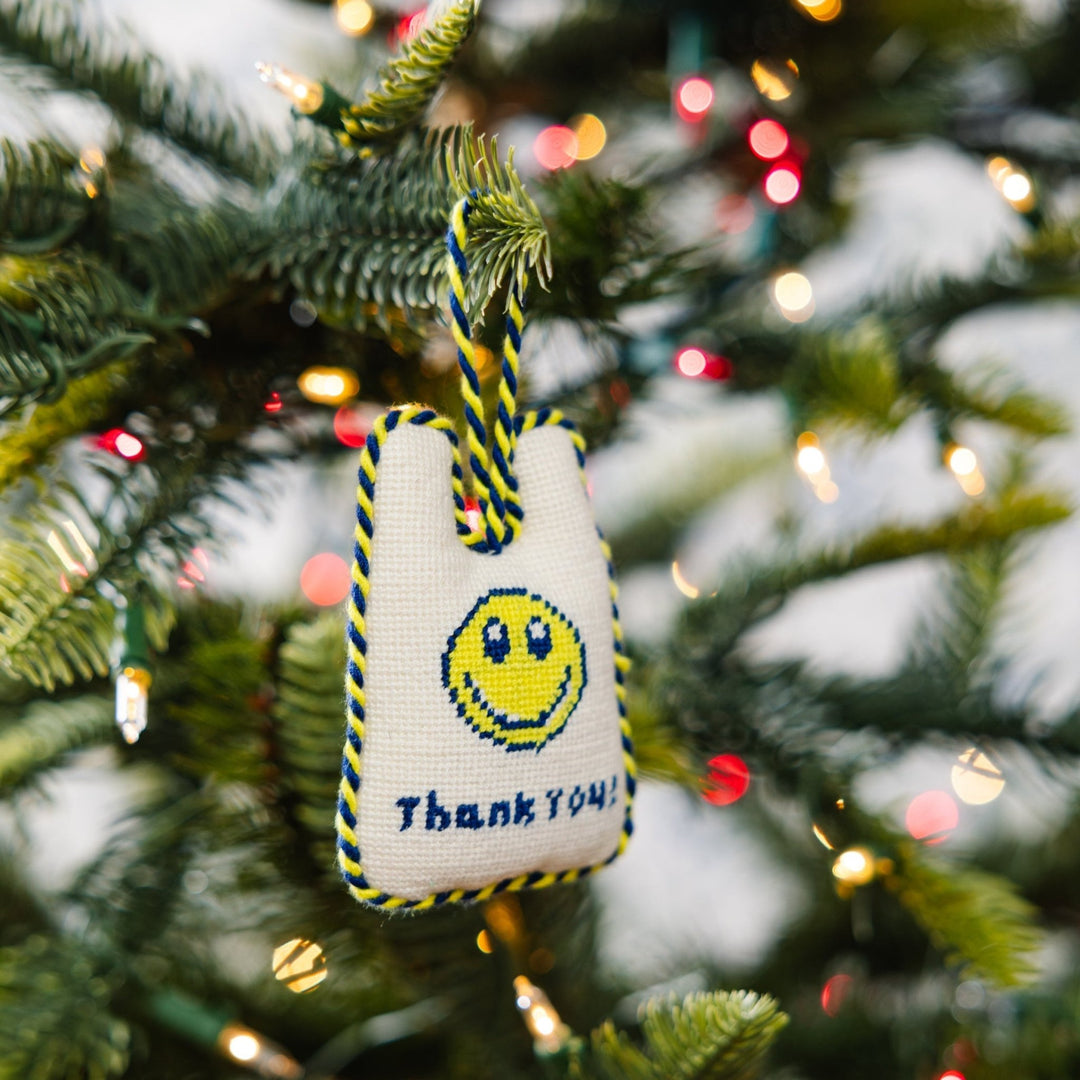 Thank You takeout bag ornament hanging from a Christmas tree branch among string lights