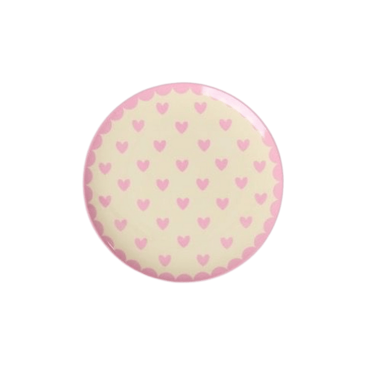 Small round cream melamine cake plate with rows of pink hearts and a pink scalloped edge, top view