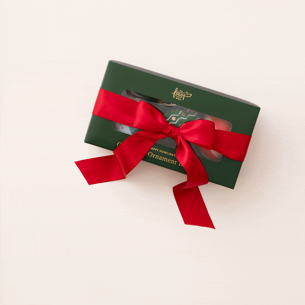 Animated clip of the ornament toy box tied with a red ribbon on a cream backdrop