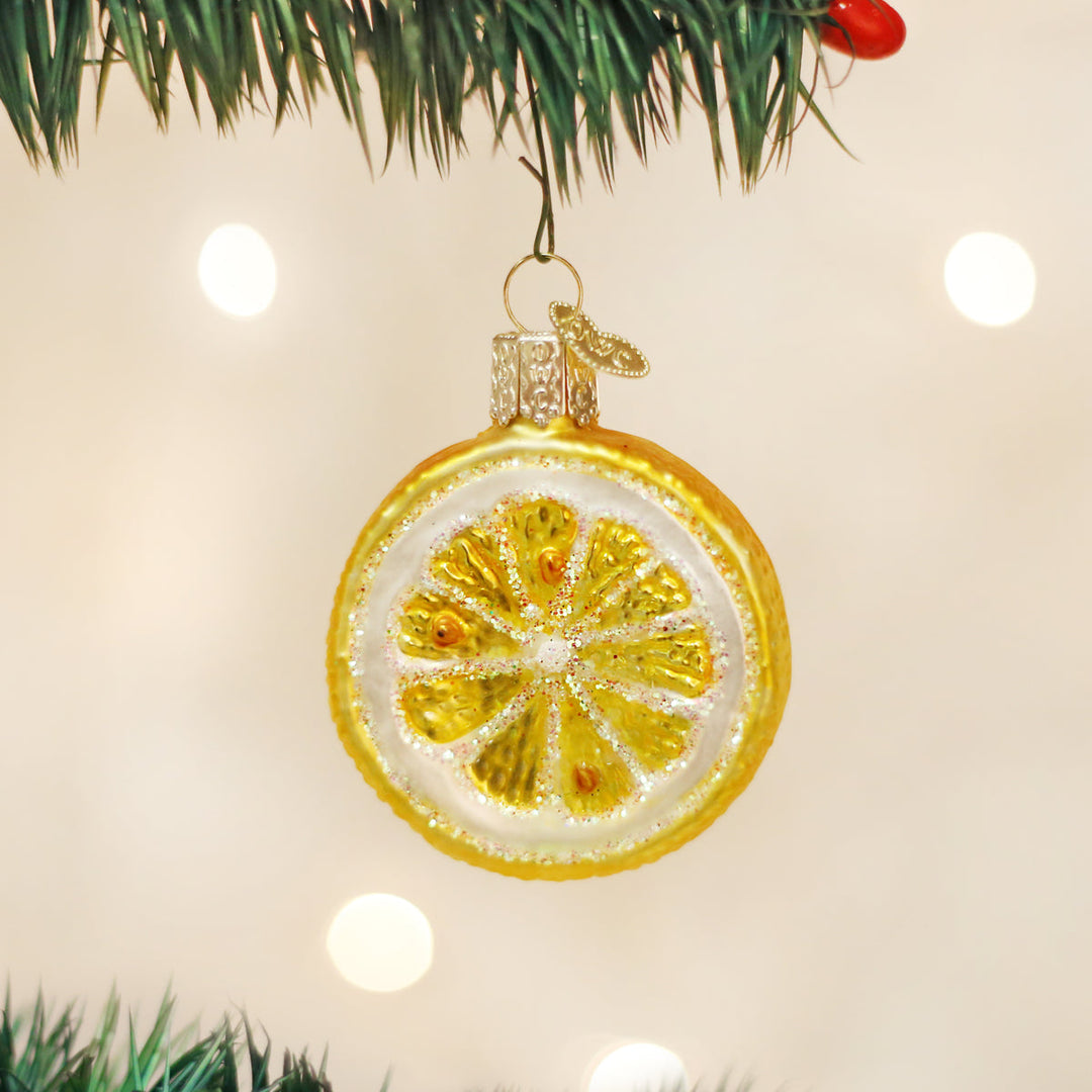 Lemon slice ornament hanging from a Christmas tree branch with soft bokeh lights for a citrus lover