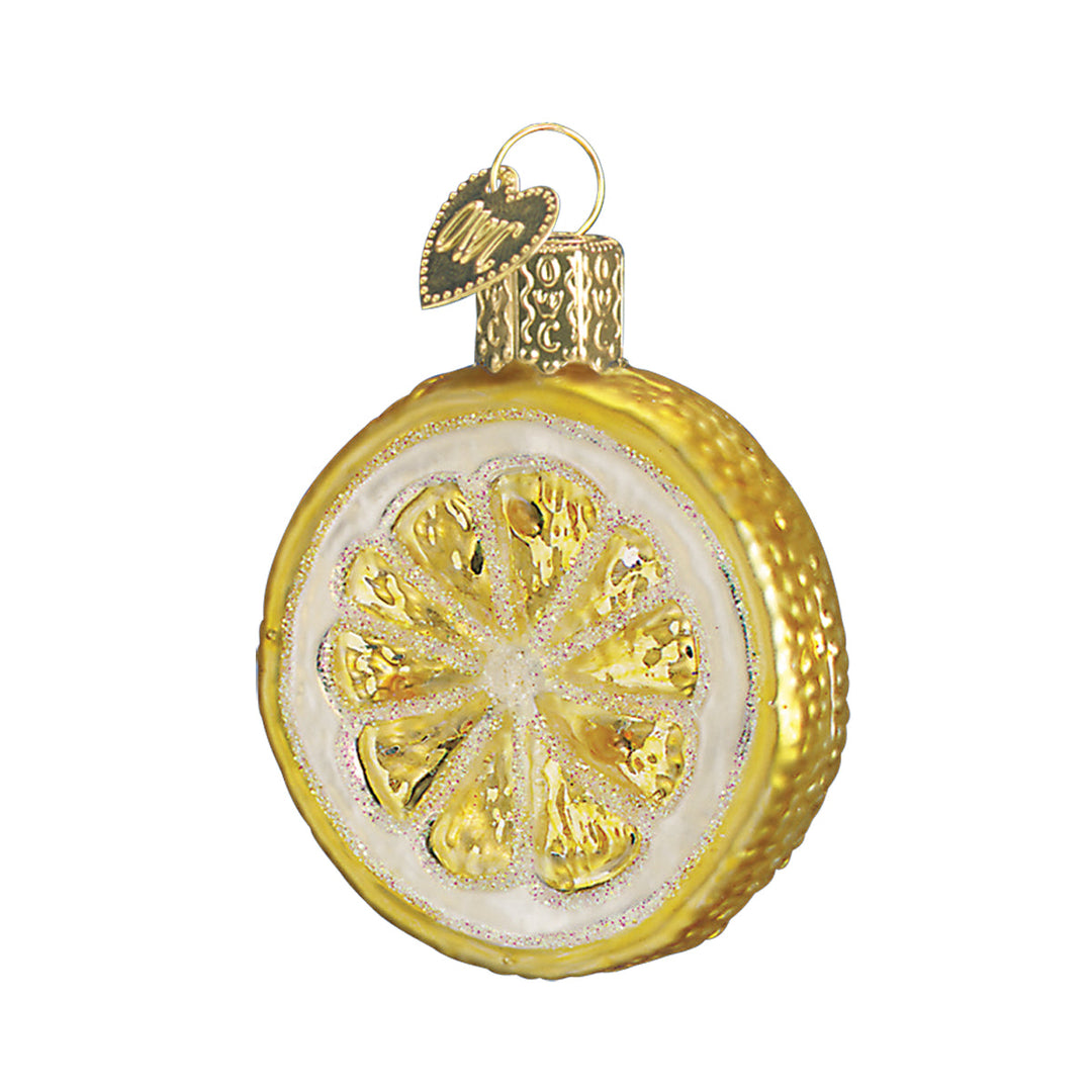 Lemon slice ornament with yellow segments, white pith, and a golden glittered rind, front view on white