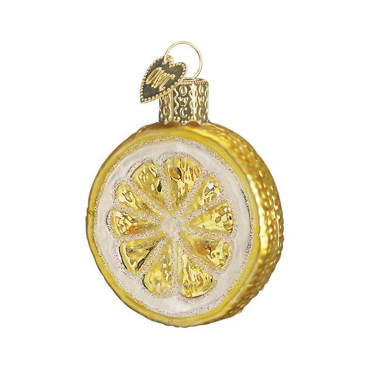 Lemon slice ornament with yellow segments, white pith, and a golden glittered rind, front view on white