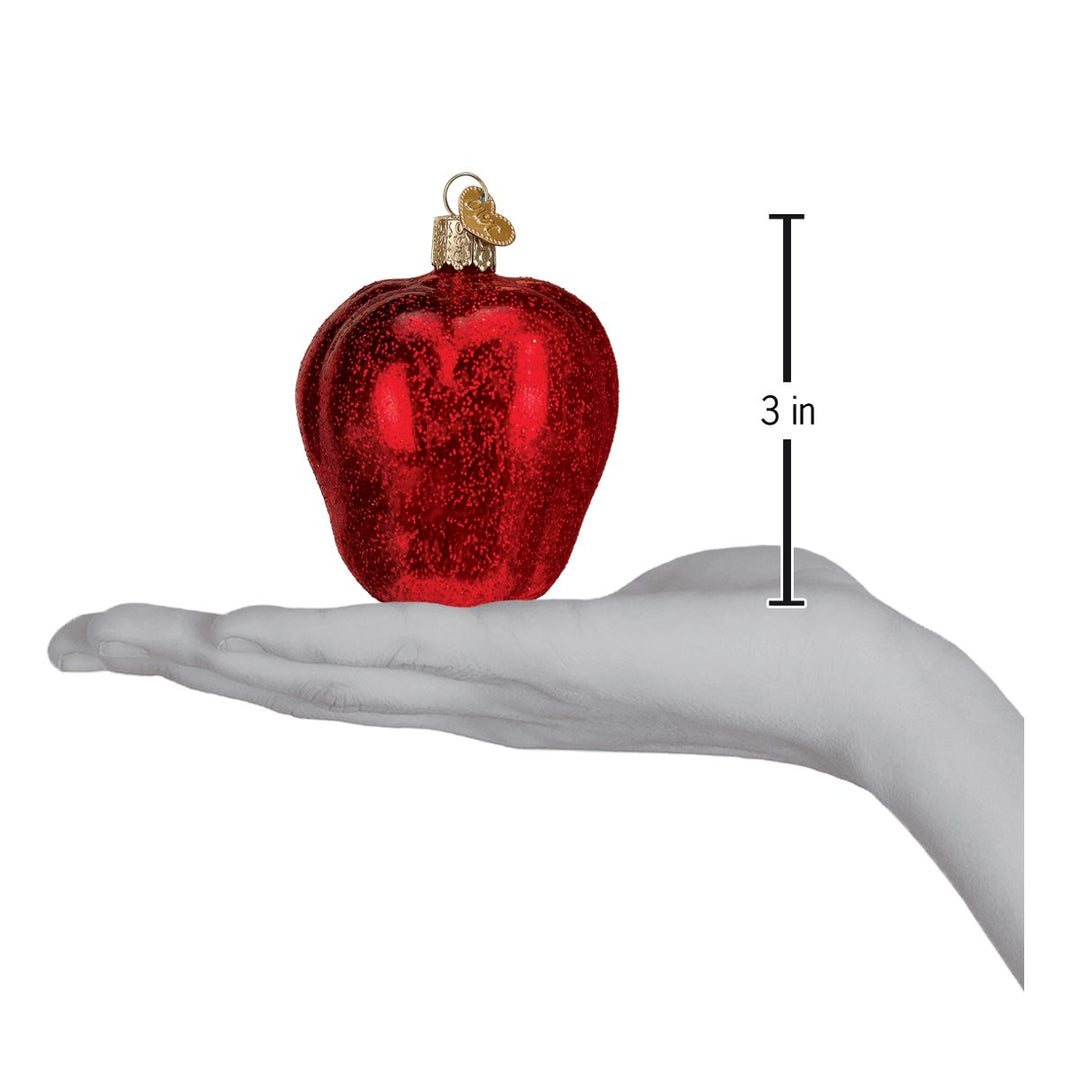 Red Delicious apple ornament resting on an open hand with a 3 inch scale marker beside it