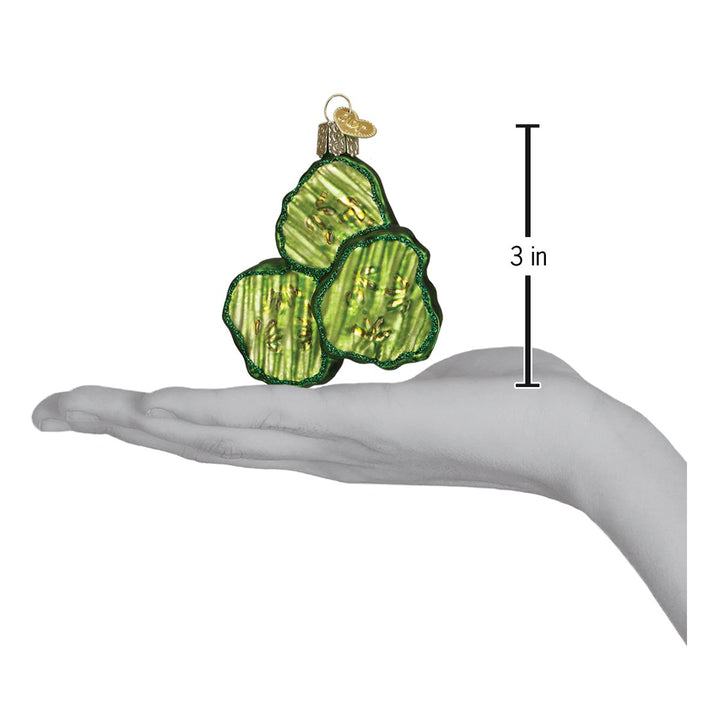 Pickle chips ornament on an open palm beside a 3 inch height marker