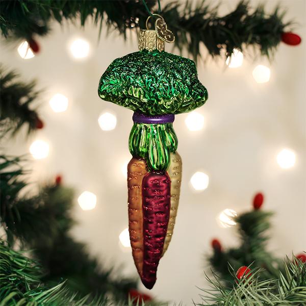 Rainbow carrots glass ornament hanging on a Christmas tree with soft white bokeh lights