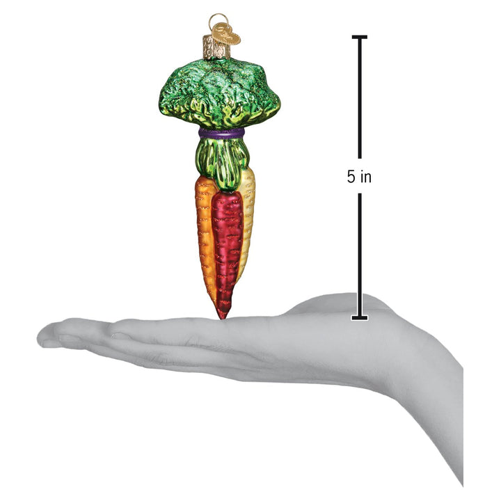 Rainbow carrots ornament standing on an open palm next to a 5 inch height marker for scale