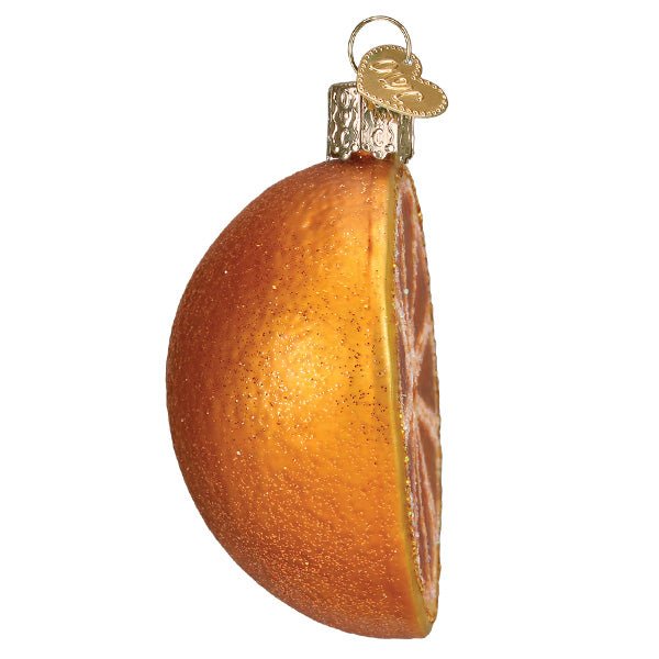 Side view of the orange slice ornament showing the rounded peel and cut edge, on white