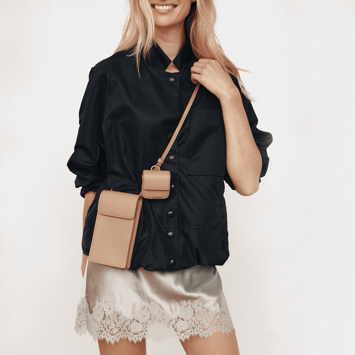 Model wearing the affogato Georgia phone sling over a black button-up shirt and satin skirt